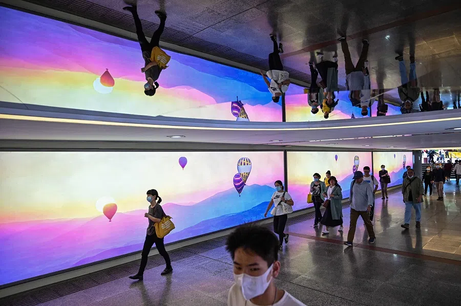 People walk near a subway station in Shanghai, China, on 12 October 2021. (Hector Retamal/AFP)