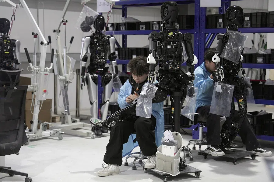 Engineers work on humanoid robots at an AgiBot factory in Shanghai, China, on 12 March 2025. (Nicoco Chan/Reuters)