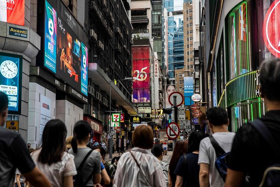 A sign (centre) with a slogan celebrating the upcoming 25th anniversary of Hong Kong's handover from Britain to China, is displayed in Hong Kong on 16 June 2022. (Isaac Lawrence/AFP)