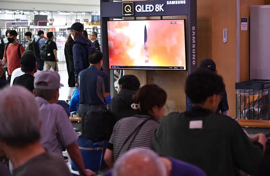 People watch a television screen showing a news broadcast with file footage of a North Korean missile test, at a railway station in Seoul, South Korea on 13 September 2023. (Jung Yeon-je/AFP)