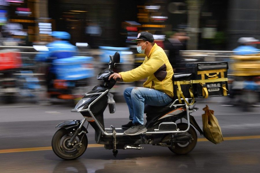 A food delivery rider heads out to make a food delivery after picking it up at a restaurant in Beijing on 27 April 2021. (Greg Baker/AFP)