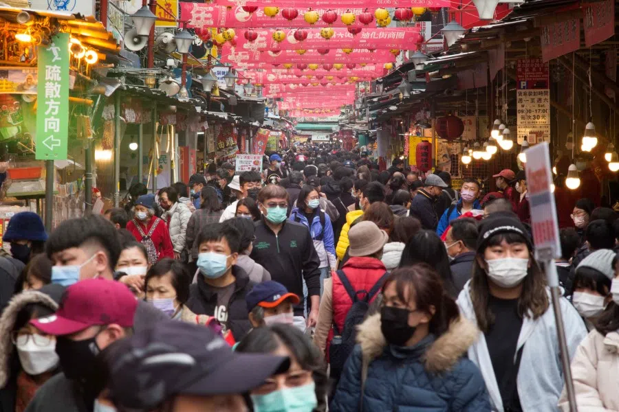 People walk under lanterns at the traditional market along Di Hua street in Taipei on 17 January 2023. (Sam Yeh/AFP)