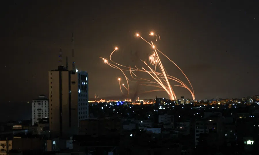 An Israeli missile launched from the Iron Dome defence missile system attempts to intercept a rocket, fired from the Gaza Strip, over the city of Netivot in southern Israel on 8 October 2023. (Mahmud Hams/AFP)