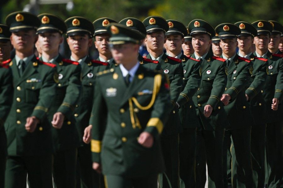 Chinese soldiers march in formation after a wreath laying ceremony at the Monument to the People's Heroes, in honour of fallen national heroes on Martyrs' Day, in Beijing's Tiananmen Square on 30 September 2023. (Photo by Pedro Pardo/AFP)