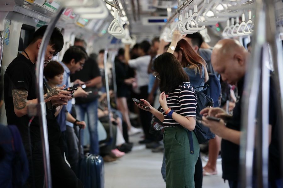 Commuters in the MRT train using their smartphones as they commute in Singapore on 17 October 2019. (SPH)