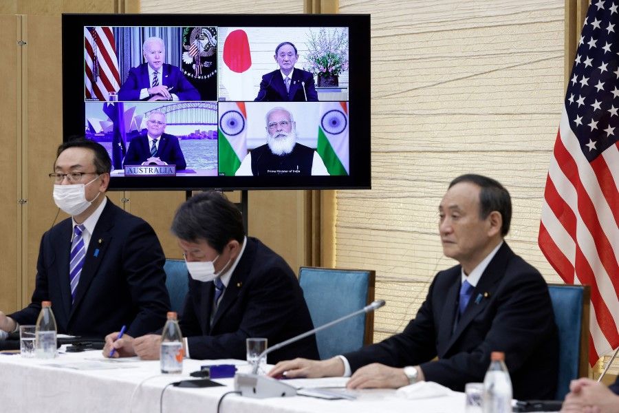 Japan's Prime Minister Yoshihide Suga (right) sits next to a monitor displaying the virtual meeting of US President Joe Biden (top left), Australia's Prime Minister Scott Morrison (bottom left) and India's Prime Minister Narendra Modi (bottom right) during the virtual Quadrilateral Security Dialogue (Quad) meeting, at his official residence in Tokyo on 12 March 2021. (Kiyoshi Ota/AFP)