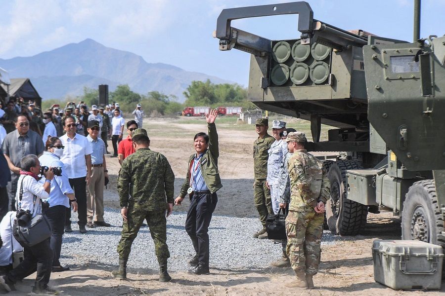 This file photo taken on 26 April 2023 shows Philippine President Marcos Jr (centre) waving to photographers after inspecting a high mobility artillery rocket system (HIMARS) before a live fire exercise as part of the US-Philippines Balikatan joint exercise at the naval training base in San Antonio, Zambales province. (Ted Aljibe/AFP)