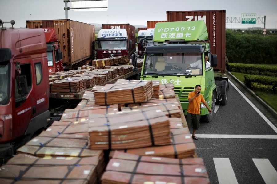 Trucks carrying copper and other goods are seen waiting to enter an area of the Shanghai Free Trade Zone, in Shanghai in this 24 September 2014 photo. (Carlos Barria/Reuters)