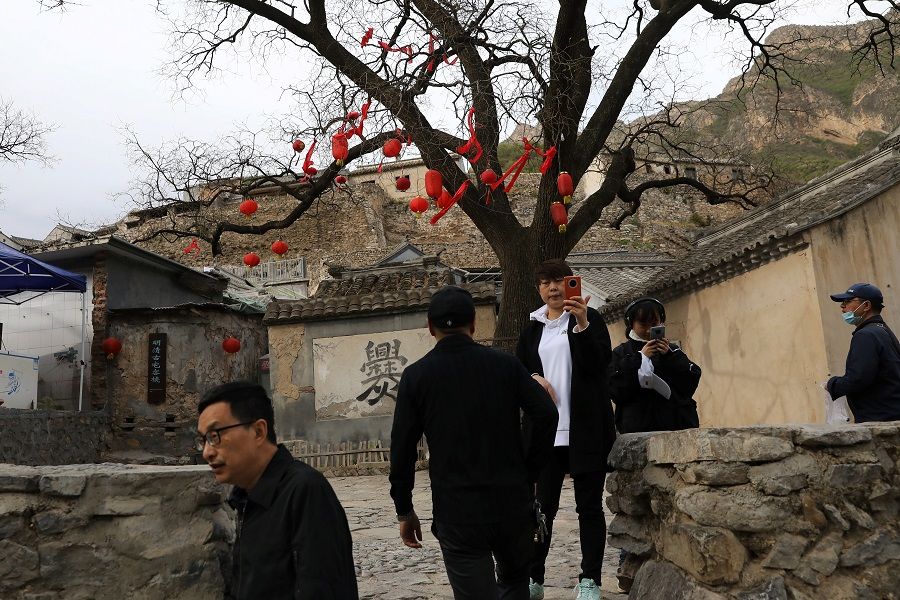 People walk through a historic village which is now a tourist attraction during the five-day Labour Day holiday in the suburbs of Beijing, China on 4 May 2021. (Tingshu Wang/Reuters)