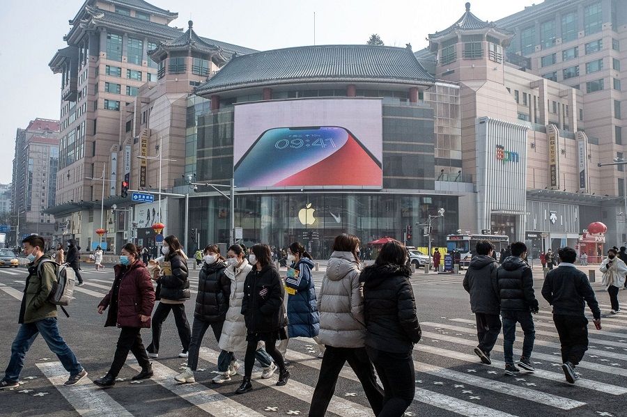 Pedestrians pass an Apple store in the Wangfujing shopping area in Beijing, China, on 10 February 2023. (Bloomberg)