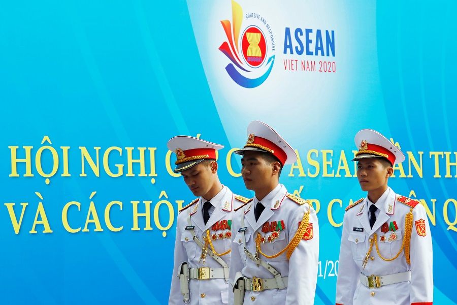 Military personnel walk past a banner promoting the ASEAN summit in Hanoi, Vietnam, 11 November 2020. (Kham/Reuters)