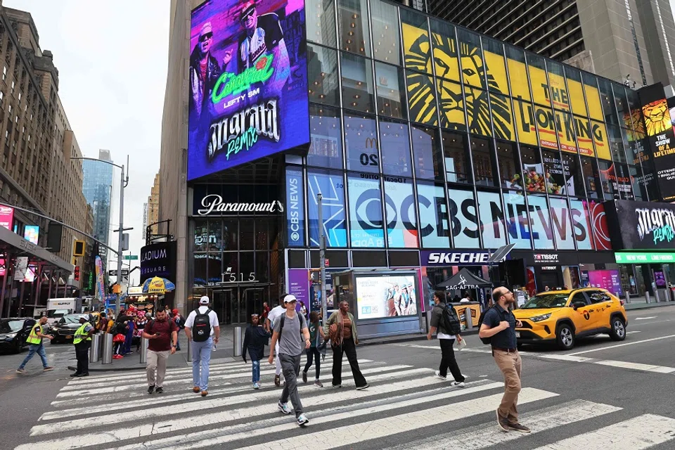 People crossing the street in front of the Paramount Global headquarters in Times Square, New York City, 8 August 2023. (Michael M. Santiago/AFP)