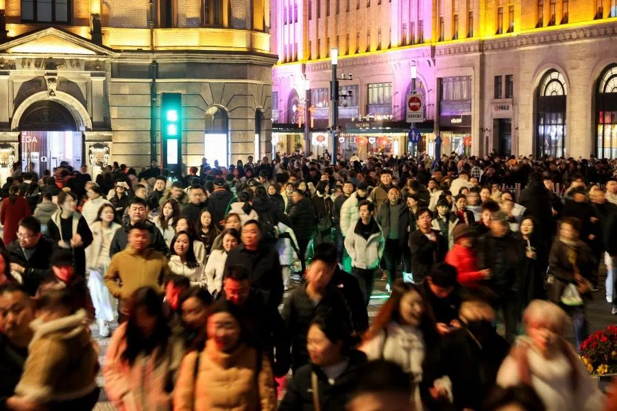 People walk across a street near the Bund in Shanghai, China, on 28 February 2026. (Go Nakamura/Reuters)