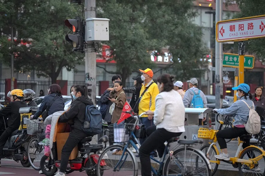 Cyclists wait at a traffic light in Beijing, China, on 11 October 2024. (Na Bian/Bloomberg)