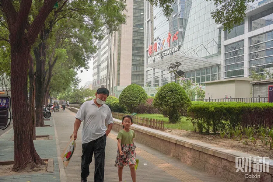 Residents pass by the E-wing Center in Haidian district of Beijing, China. (Zhang Ruixue/Caixin)