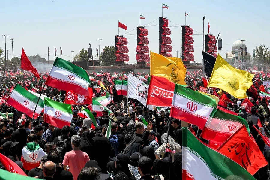 Mourners gather with flags and banners during a funeral procession for Iran’s slain supreme leader Ali Khamenei and his family members near Azadi Square in Tehran on 6 July 2026.