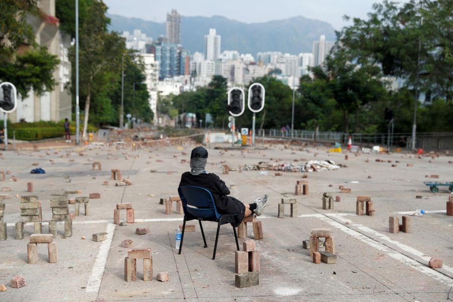 A protester sits amid a road block outside City University in Kowloon Tong on November 12, 2019. (REUTERS/Thomas Peter)