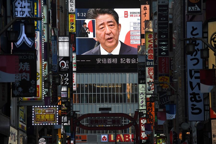 Japan Prime Minister Shinzo Abe is seen on a large screen during a live press conference in Tokyo on 28 August 2020. (Philip Fong/AFP)