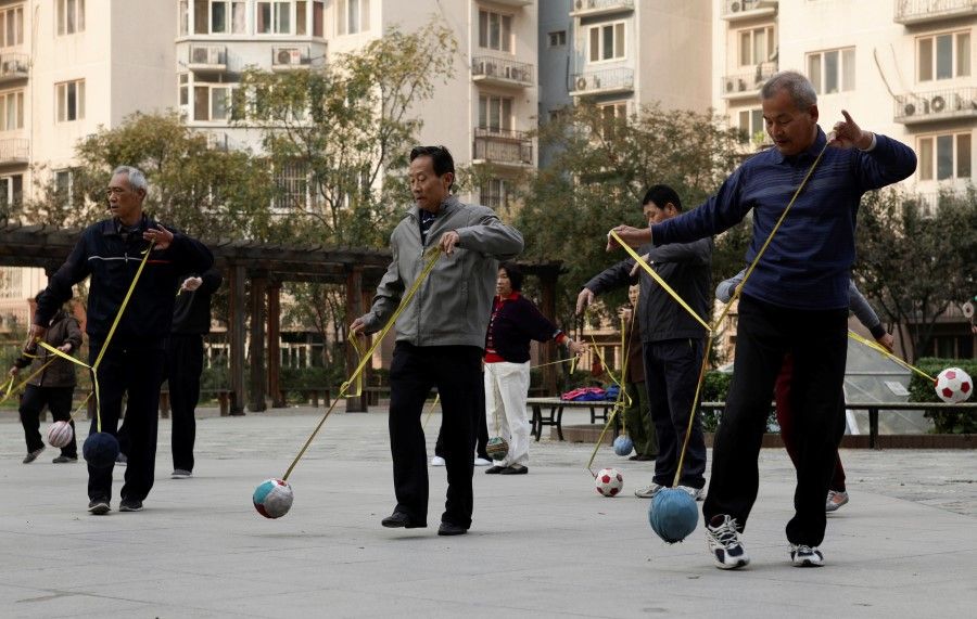 Retirees practice "Cola Ball" with music, an invented community activity in central Beijing, 17 October 2013. (Iris Zhao/Reuters)