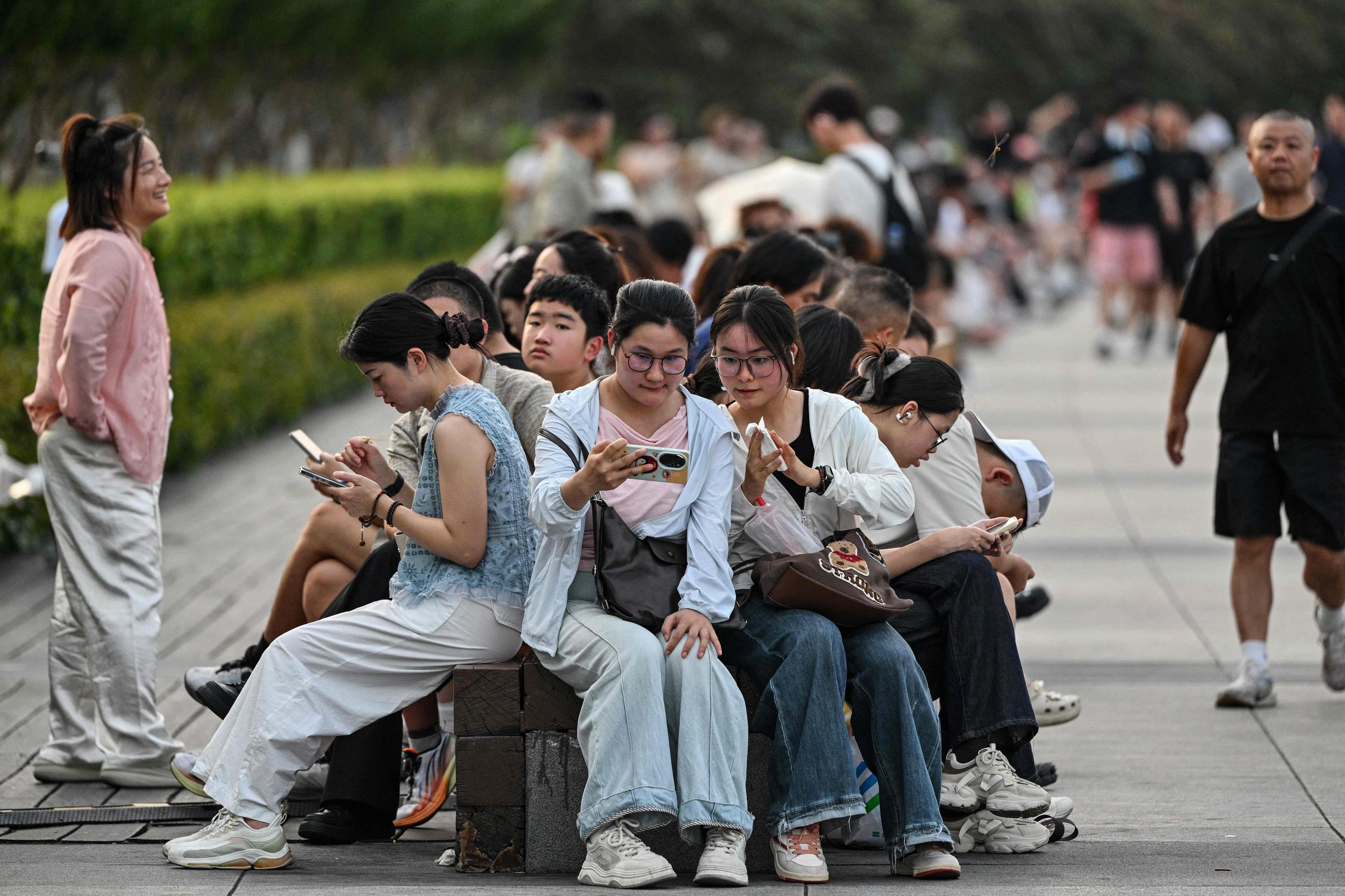 People visit the Bund promenade along the Huangpu river in Shanghai on 17 July 2026.