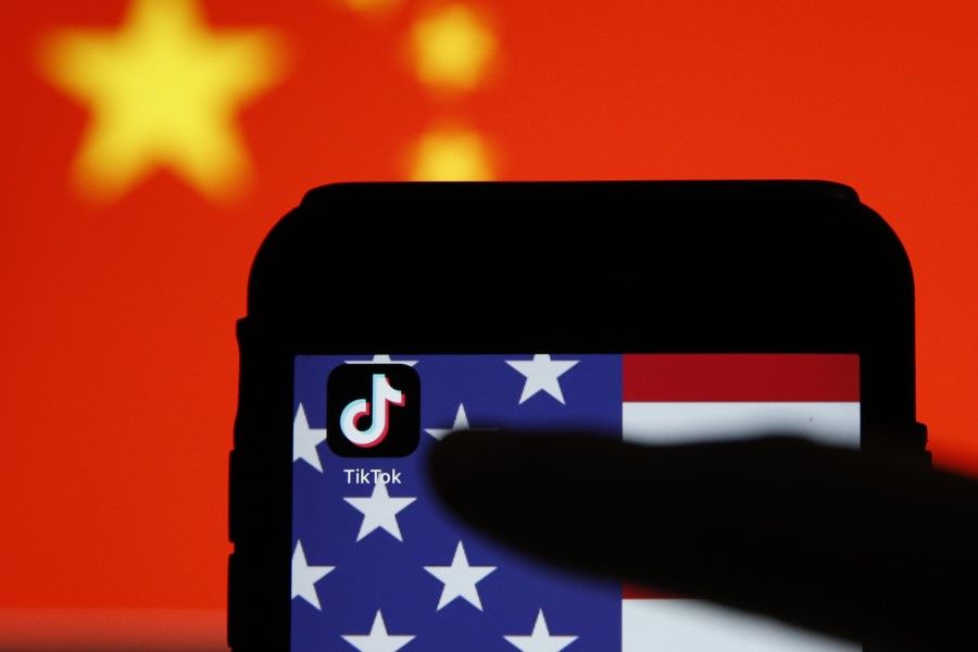 The TikTok app icon sits displayed on a smartphone in front of the national flags of China and the US in this arranged photograph in London, 3 August 2020. (Hollie Adams/Bloomberg)