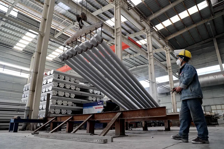 This picture taken on 24 February 2025 shows a worker processing aluminium rods at an aluminium-base material factory in Binzhou, Shandong province, China. (AFP)