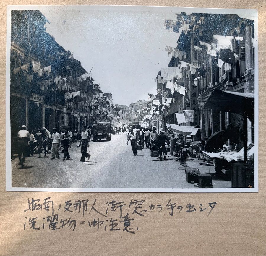 A street in Chinatown, Singapore, late February 1942. The caption says to look out for the laundry poles above.