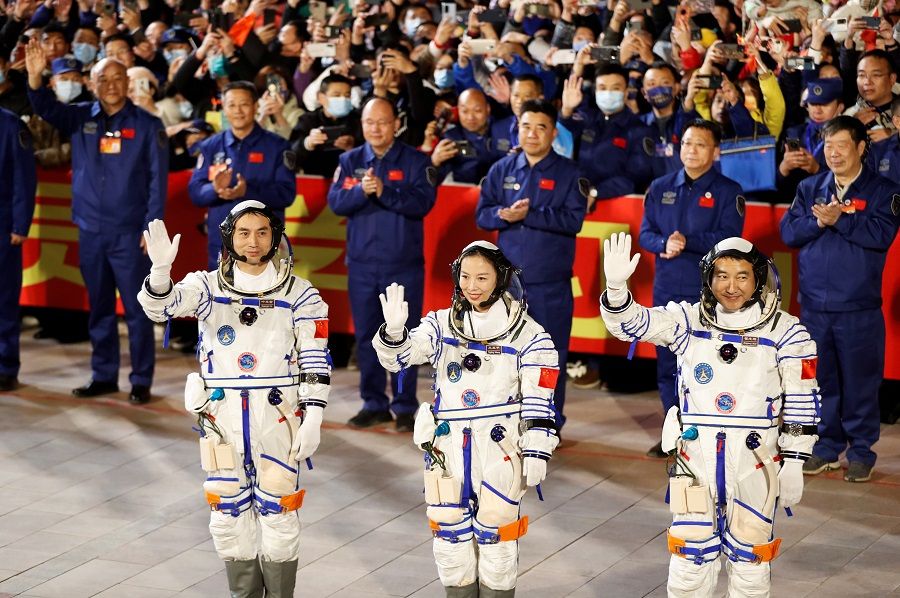 Astronauts (from left) Ye Guangfu, Wang Yaping and Zhai Zhigang wave during a ceremony ahead of the launch of the Long March-2F Y13 rocket, carrying the Shenzhou-13 spacecraft and them in China's second crewed mission to build its own space station, at Jiuquan Satellite Launch Center near Jiuquan, Gansu province, China, 15 October 2021. (Carlos Garcia Rawlins/Reuters)
