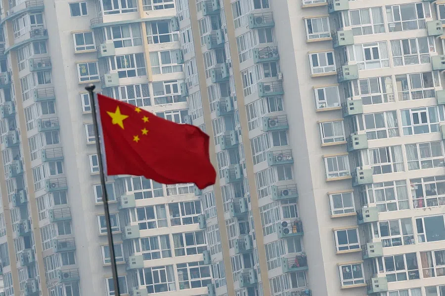 A Chinese national flag flutters near residential buildings in Beijing, China, on 9  March 2025. (Tingshu Wang/Reuters)