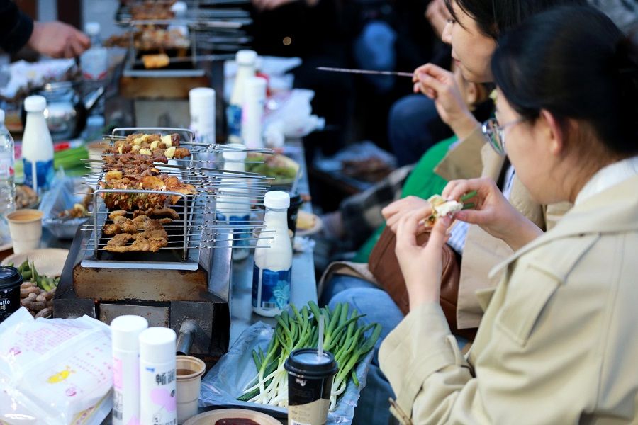 People eat barbecue at a barbecue eatery in Zibo, Shandong province, China, 31 March 2023. (CNS)