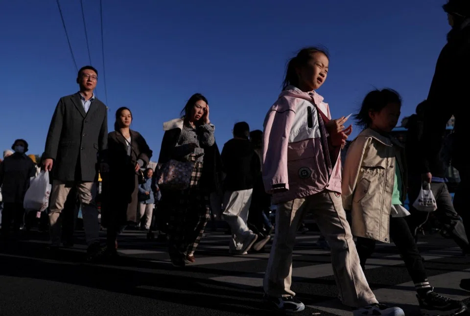 People walk on a street in Beijing, China, 19 October 2025. (Tingshu Wang/Reuters)