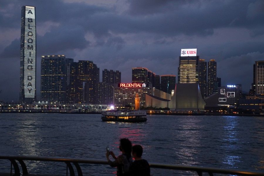 A Star Ferry cruises past high-rise buildings in Tsim Sha Tsui district after sunset in Hong Kong, China, 30 March 2021. (Lam Yik/Reuters)