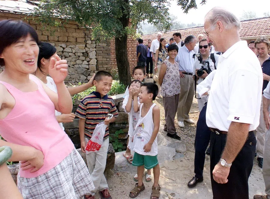 This file photo taken on 10 August 2001 shows US President-elect Joe Biden (right) sharing a light moment with villagers in Yanzikou, north of Beijing. (Greg Baker/AFP)