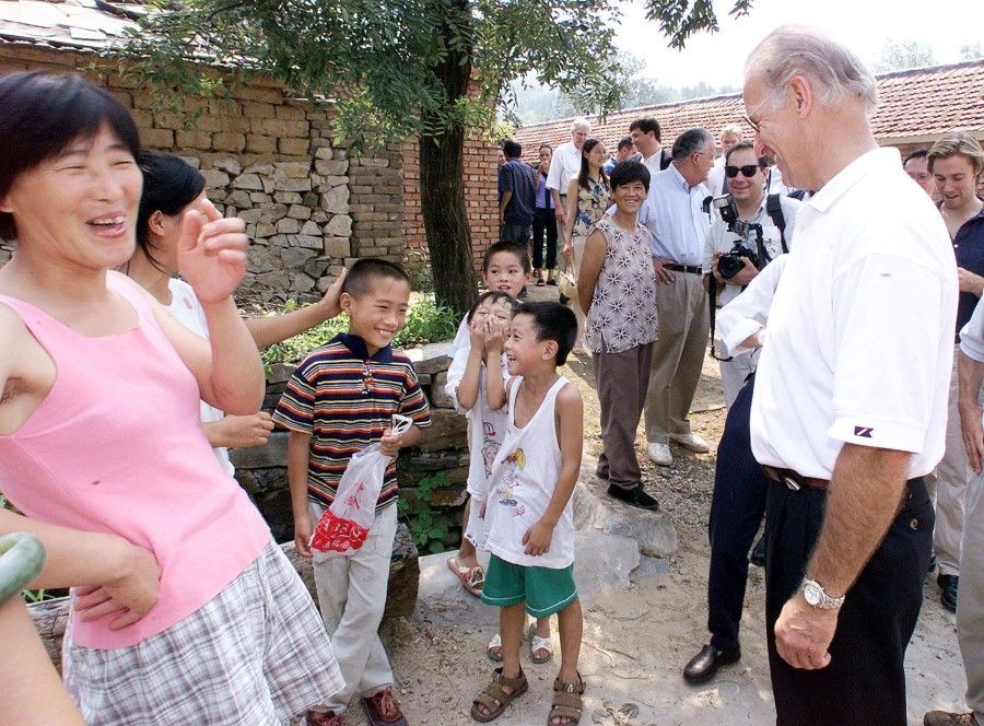 This file photo taken on 10 August 2001 shows US President-elect Joe Biden (right) shares a light moment with villagers in Yanzikou, north of Beijing. (Greg Baker/AFP)