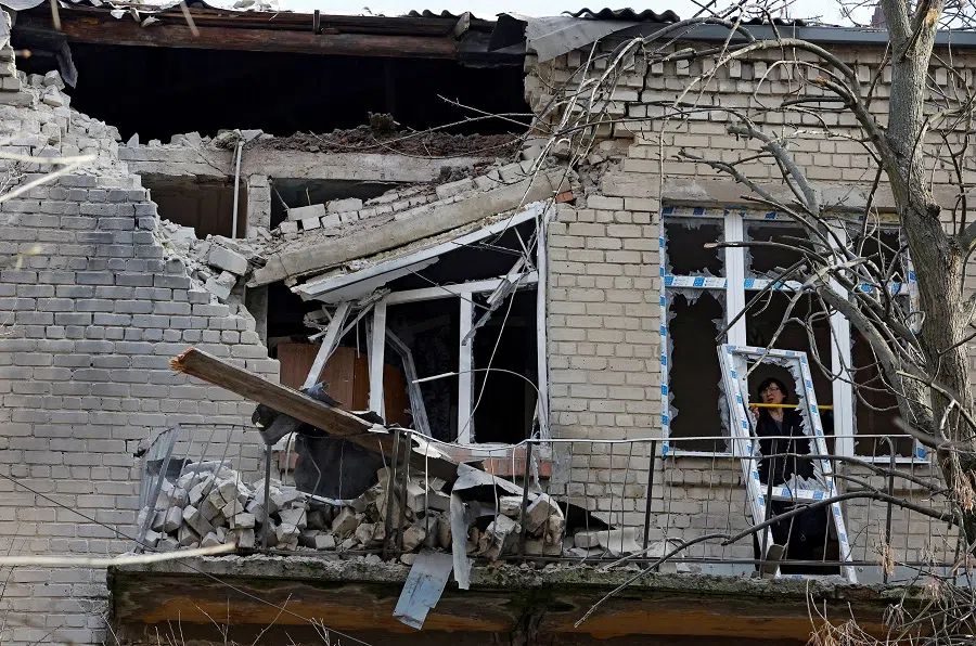 A woman measures the size of a broken hospital window following recent shelling in the course of the Russia-Ukraine conflict in Donetsk, Russian-controlled Ukraine, 15 December 2022. (Alexander Ermochenko/Reuters)