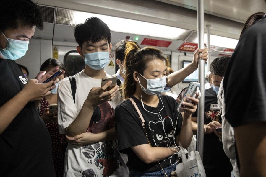 Commuters wearing protective masks ride on board a subway train during the morning rush hour in Shanghai, China, on 6 August 2021. (Qilai Shen/Bloomberg)