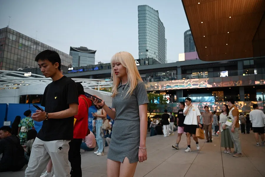 People walk in a shopping mall in Beijing, China, on 16 September 2024. (Greg Baker/AFP)