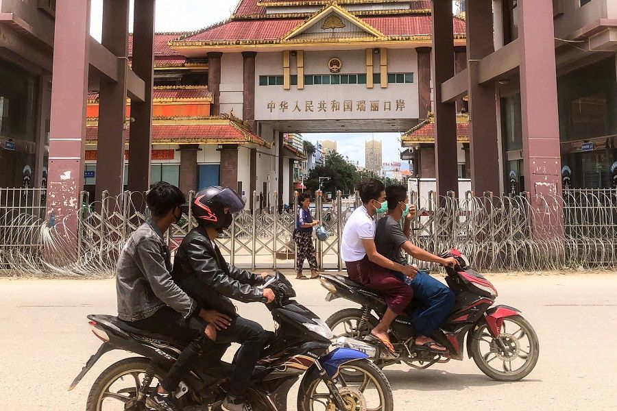 Motorists pass the China-Myanmar border gate in Muse in Shan state, Myanmar, on 5 July 2021. (STR/AFP)