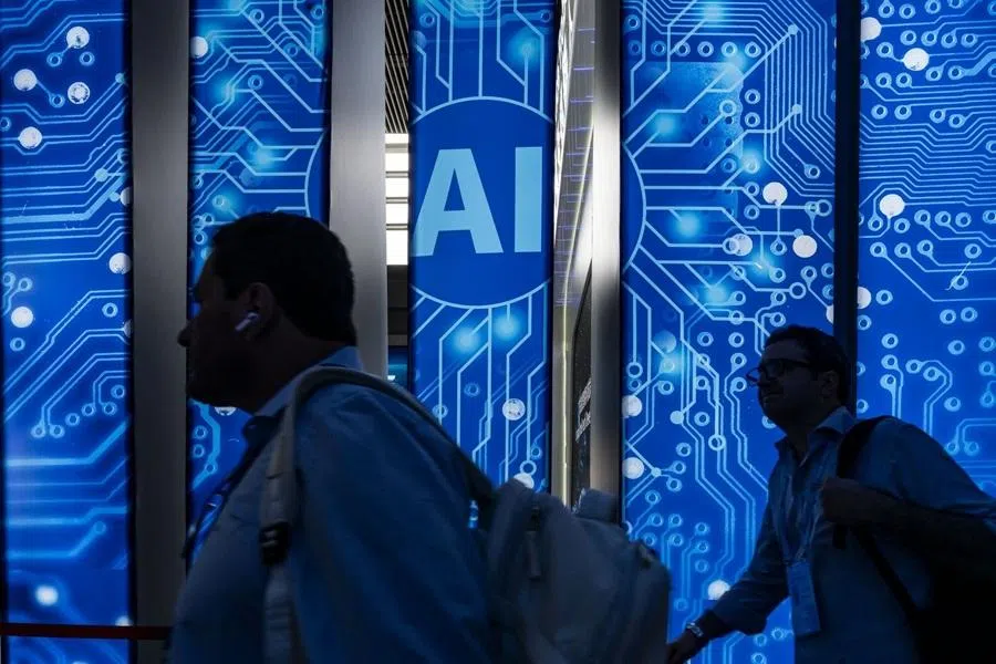 Attendees walk past artificial intelligence (AI) signage at the Canton Fair in Guangzhou, China, 15 April 2026. (Qilai Shen/Bloomberg)