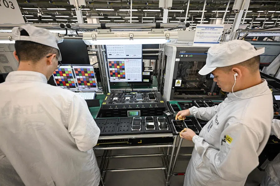 This photo taken on 22 October 2025 shows employees working on an Honor Magic 8 smartphone production line at a factory of Chinese smartphone company Honor in Shenzhen, in southern China's Guangdong province. (Jade Gao/AFP)