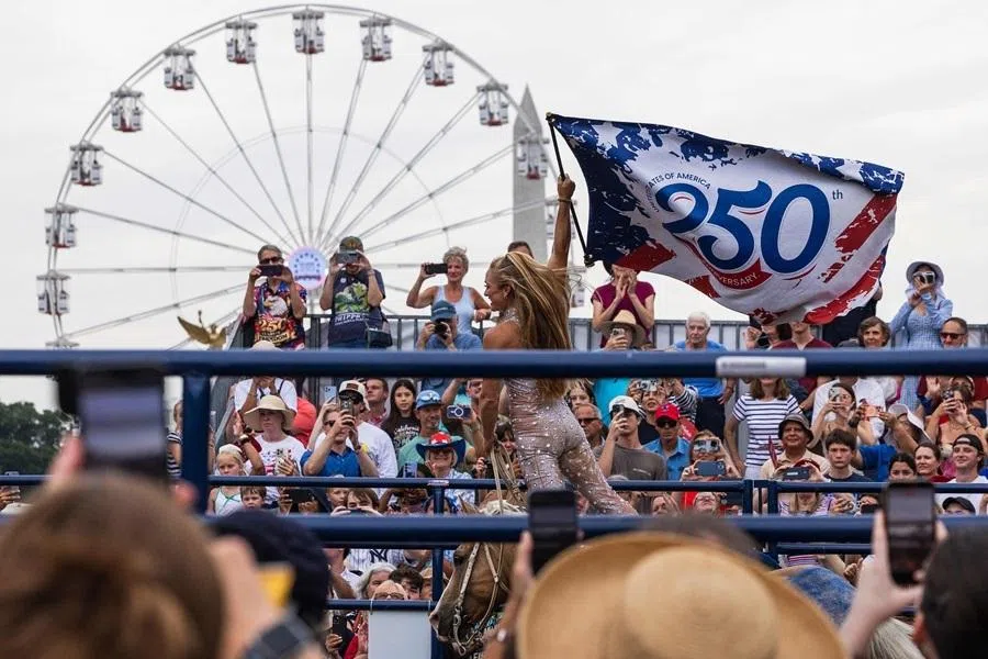 People gather to watch "The Evolution of the American Cowboy" in front of the Freedom 250 Ferris wheel on 10 July 2026 in Washington, DC.