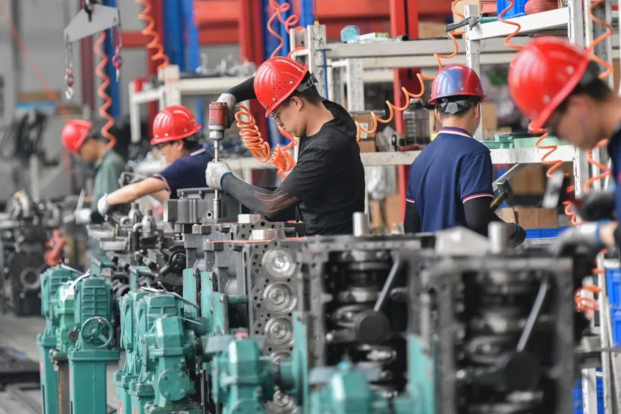 Employees work at a tractor and truck motor manufacturing company in Qingzhou, in eastern China's Shandong province, on 27 August 2025. (STR/AFP)