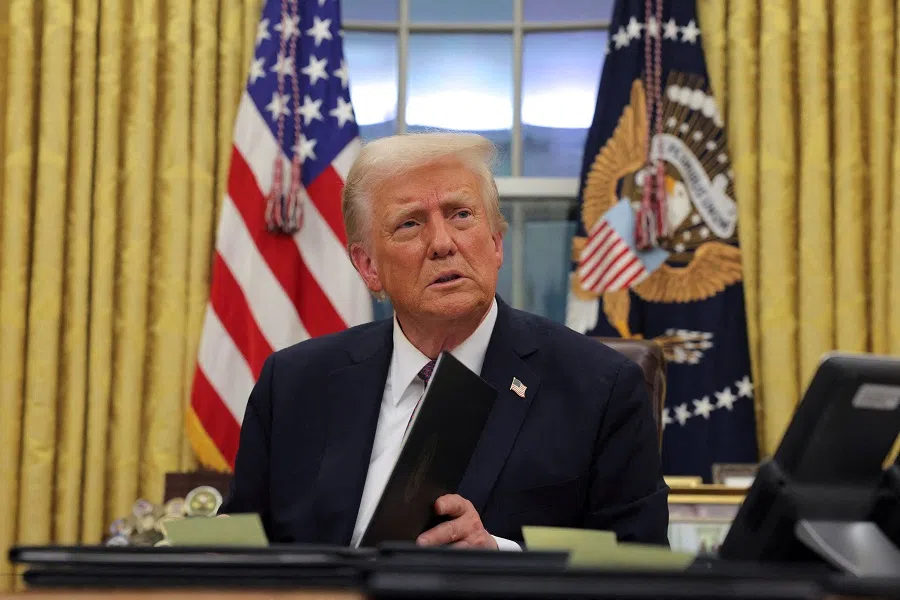 US President Donald Trump signs documents in the Oval Office at the White House on Inauguration Day in Washington, US, on 20 January 2025.