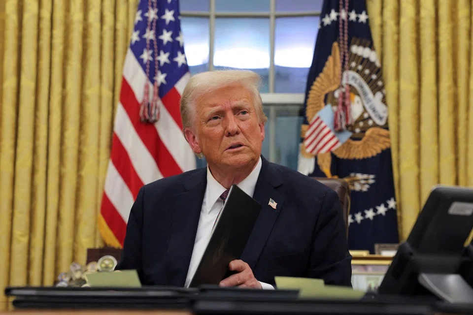US President Donald Trump signs documents in the Oval Office at the White House on Inauguration Day in Washington, US, on 20 January 2025. (Carlos Barria/Reuters)