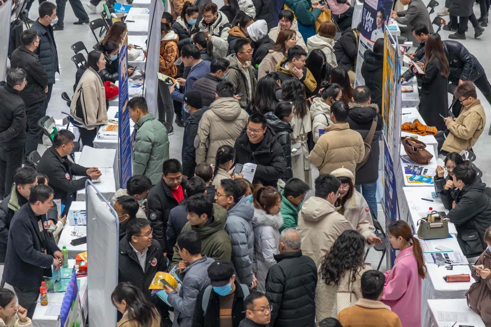 People attend a job fair in Henan, China, on 19 February 2024. (AFP)