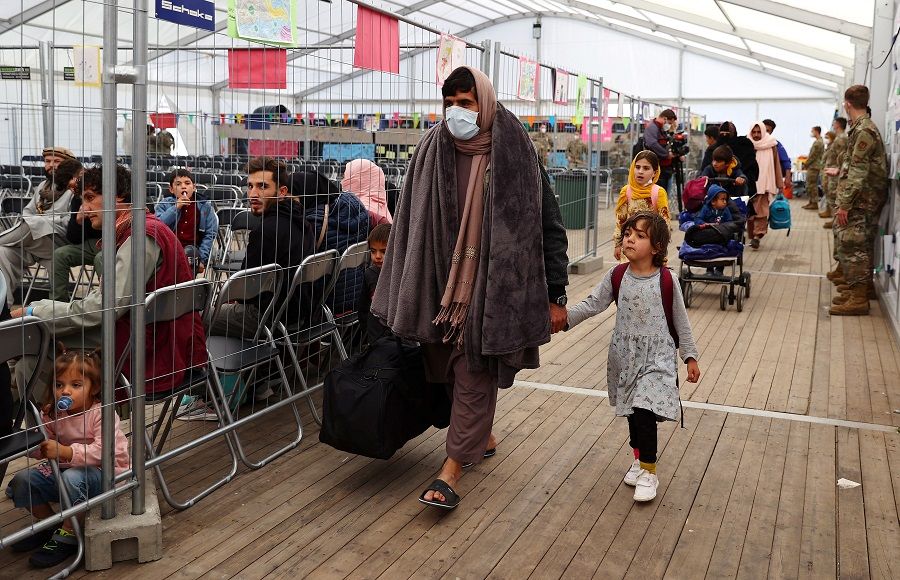 Evacuees from Afghanistan walk at the US air base in Ramstein before boarding commercial planes for the US, in Germany, 9 October 2021. (Kai Pfaffenbach/Reuters)
