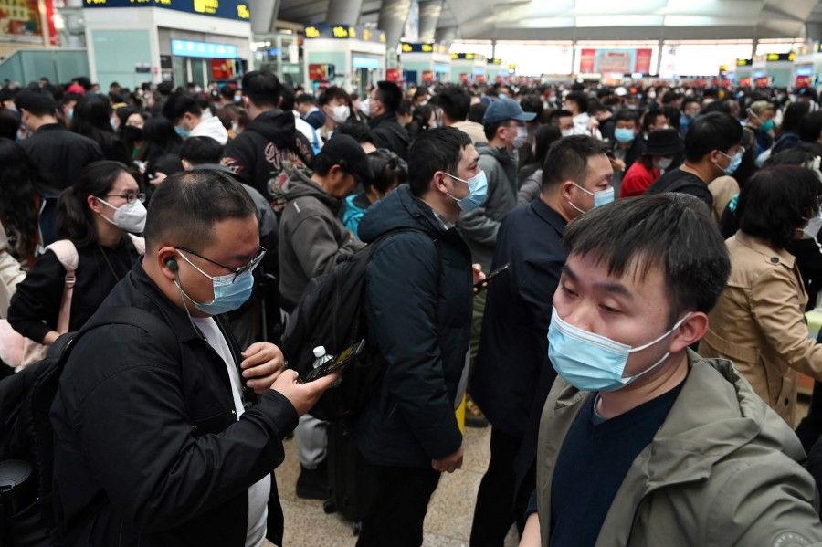 Passengers wait to board a train at a railway station in Beijing, China, on 27 March 2023. (Greg Baker/AFP)