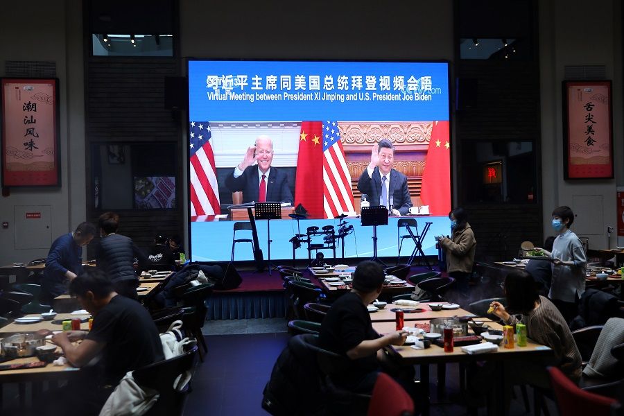 A screen shows Chinese President Xi Jinping attending a virtual meeting with US President Joe Biden via video link, at a restaurant in Beijing, China, 16 November 2021. (Tingshu Wang/Reuters)