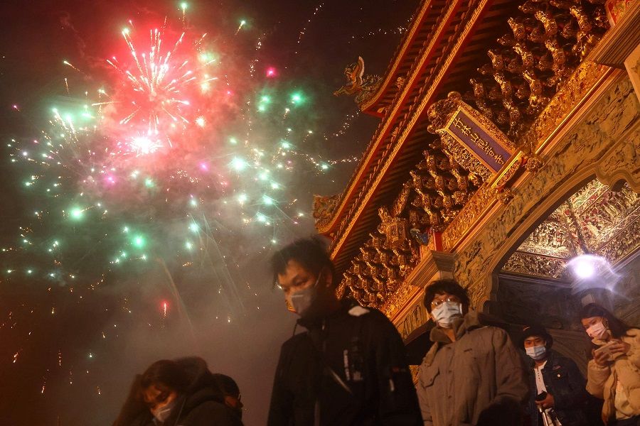 Lunar New Year fireworks go off as people wait to enter a temple in Taipei, Taiwan, 12 February 2021. (Ann Wang/Reuters)