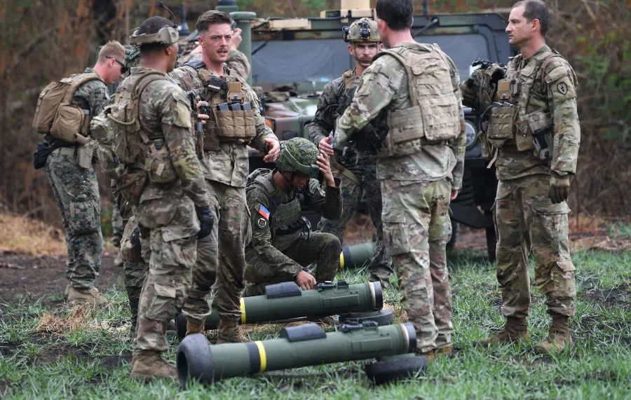 A Philippine soldier (centre) arranges a Javelin anti-tank weapon system next to US soldiers during a live exercise as part of the US-Philippines joint military exercise "Balikatan" at Fort Magsaysay in Nueva Ecija province, north of Manila on 13 April 2023. (Ted Aljibe/AFP)